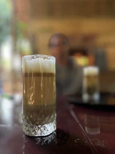 a glass of beer sitting on top of a table at Vanar Climbs Hampi in Hampi