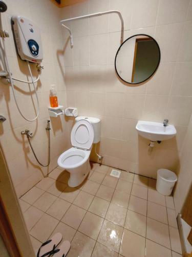 a bathroom with a toilet and a sink and a mirror at MunadibStay Calm in Kota Bharu