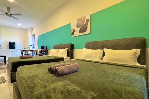 a bedroom with two beds and a green wall at Core Soho Luxury Designer Suite KLIA in Sepang