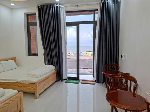 a bedroom with a bed and a view of the beach at Oyster Homestay in Chợ Phước Hải