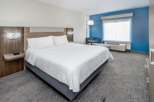 a hotel room with a large bed and a window at Holiday Inn Express & Suites Denver North - Thornton by IHG in Thornton