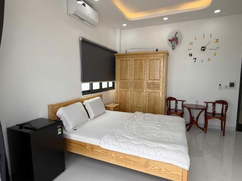 a bedroom with a bed and a table with chairs at Oyster Homestay in Chợ Phước Hải