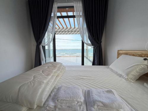 a bedroom with a bed with a view of the ocean at Oyster Homestay in Chợ Phước Hải