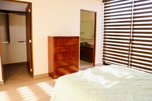 a bedroom with a bed and a dresser and a mirror at Privada, Casa Real Flamingos , Nayarit in Bucerías