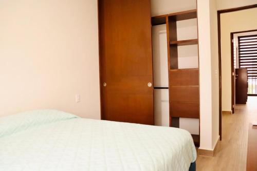 a bedroom with a bed and a wooden closet at Privada, Casa Real Flamingos , Nayarit in Bucerías