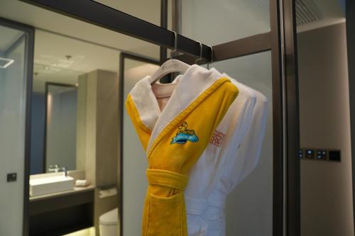 a robe hanging on a rack in a bathroom at Ronghuitong SSAW Hotel in Changzhi
