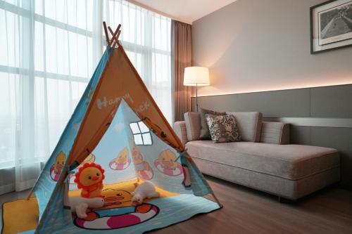 a play tent in a living room with a couch at Ronghuitong SSAW Hotel in Changzhi
