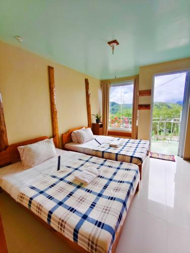 zwei Betten in einem Zimmer mit zwei Fenstern in der Unterkunft Best Barkada Staycation in Sagada - Unit 2 in Sagada