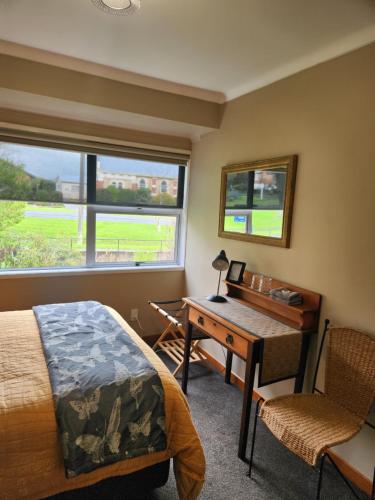 a bedroom with a desk and a bed and a desk at The Nunnery in Te Aroha
