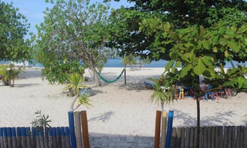 a beach with trees and a hammock on the beach at Ocean holiday in Bira