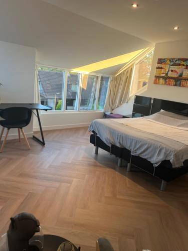 En eller flere senge i et værelse på Ruime slaap kamer met werkplek en privé badkamer bij Jacqueline