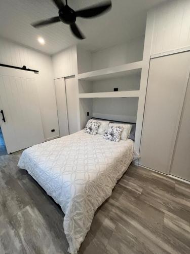a bedroom with a bed and a ceiling fan at Cute and cosy 1 bedroom cabin in Mooloolah