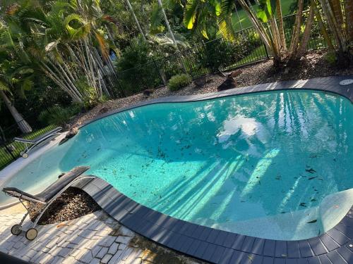 a swimming pool with a bench and a chair in it at Cute and cosy 1 bedroom cabin in Mooloolah
