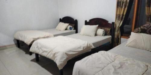a room with three beds in a room at Ocean holiday in Bira