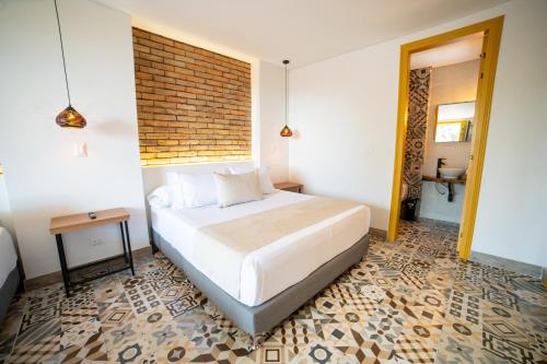 a bedroom with a bed and a brick wall at Casa Serafin Hotel in Salento