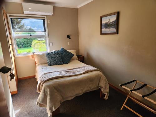 a small bedroom with a bed and a window at The Nunnery in Te Aroha
