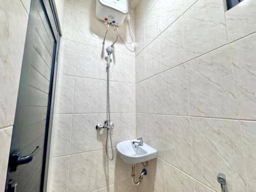 ジャカルタにあるNest Kostel at Kebayoran South Jakarta by Le Ciel Stayのシャワーと洗面台付きのバスルーム