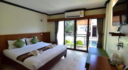 a bedroom with a large bed and a balcony at The Green Hotel in Ko Lipe