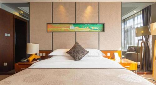 a bedroom with a large bed in a room at The Prosperous City Hotel Weifang in Weifang