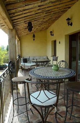 un patio avec une table et des chaises sur un balcon dans l'établissement Les Gîtes du Lac, à Montauroux