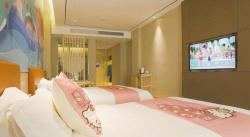 a hotel room with two beds and a flat screen tv at Quanzhou Binhai Hotel in Quanzhou