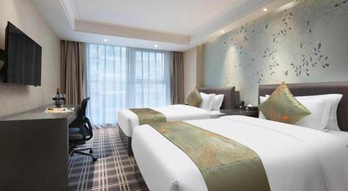 a hotel room with two beds and a desk at Yongzhou Chuang Fa Cheng XiaoXiangYi Hotel in Guzhuting