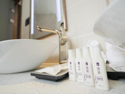 a bathroom counter with two white bottles on a sink at Lavande Hotel·Tianmen Xincheng in Tianmen
