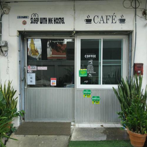 a store front of a coffee shop with a window at Sleepwith me Hostel in Bangkok