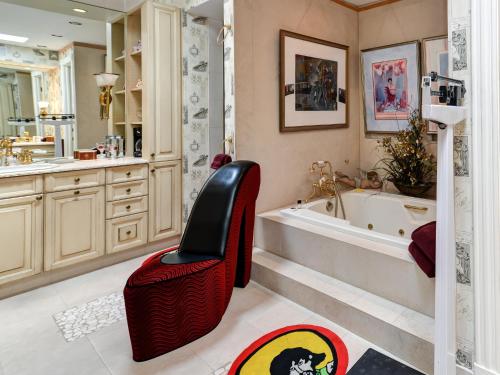 ein Badezimmer mit einer Badewanne und einem roten Stuhl. in der Unterkunft The Mansion on O Street in Washington