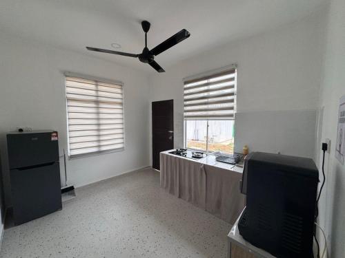 a kitchen with a table and a ceiling fan at D' Ehsan Homestay & Chalet in Kuala Terengganu