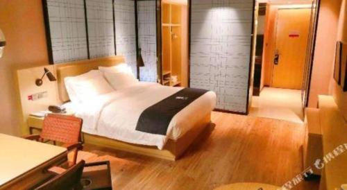 a bedroom with a large bed and a desk and a room at Echarm Hotel Changde Taoyuan Walking Street Jinyuan Tower in Changde