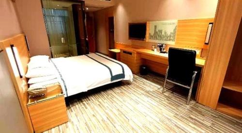 a bedroom with a bed and a desk with a computer at City Comfort Inn Yingcheng Railway Station Shanghe Square in Xiaogan
