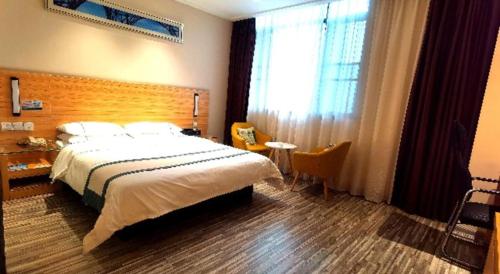 a bedroom with a large bed and a large window at City Comfort Inn Yingcheng Railway Station Shanghe Square in Xiaogan