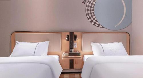 two beds sitting next to each other in a room at City Comfort Inn Liuzhou High-speed Railway Station in Liuzhou