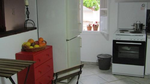 a kitchen with a bowl of fruit on a red dresser at Trouli House in Stalos