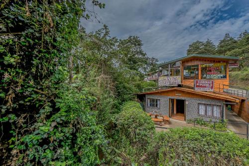a building with a food stand on top of a hill at Cabinas El Pueblo B&B Monteverde in Monteverde Costa Rica