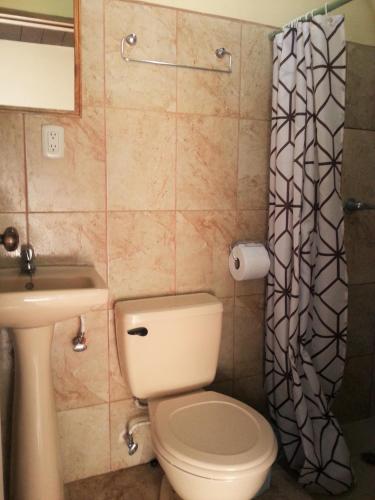a bathroom with a toilet and a sink at Casa Inti Guesthouse & Lodge in Managua