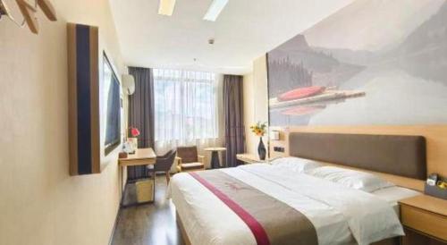 a bedroom with a bed and a painting on the wall at Thank Inn Plus Hotel Guangdong Yunfu Luoding City Municipal in Yunfu