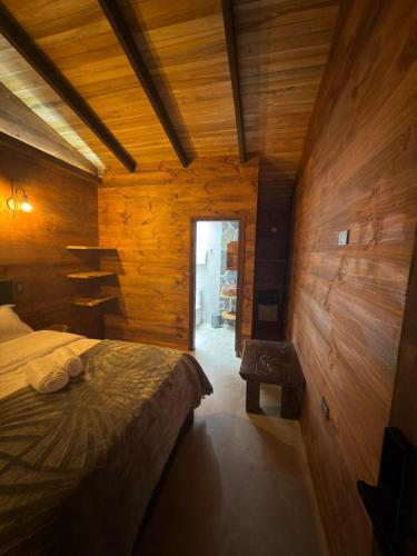a bedroom with a bed and a wooden wall at Casa Campestre Los Nevados Patio Bonito in Estación El Salto