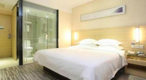 a bedroom with a large white bed and a shower at City Comfort Inn Qingyuan Longtang Light Rail Changlong in Qingyuan