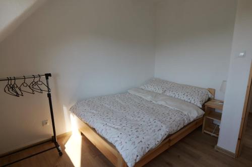 a bed in a room with a white wall at Słońce i cień in Baligród