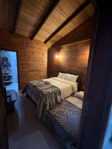 a bedroom with a bed in a wooden room at Casa Campestre Los Nevados Patio Bonito in Estación El Salto