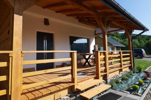 a wooden deck of a house with a table at Słońce i cień in Baligród