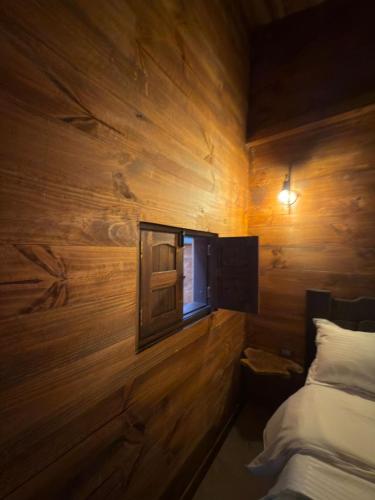 a room with a wooden wall with a bed and a window at Casa Campestre Los Nevados Patio Bonito in Estación El Salto