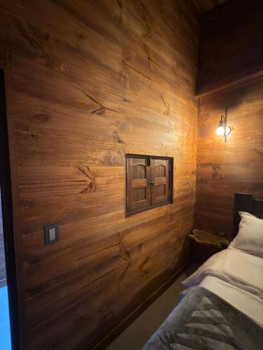 a bedroom with wooden walls and a bed in it at Casa Campestre Los Nevados Patio Bonito in Estación El Salto