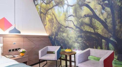 a room with two chairs and a painting on the wall at Borrman Hotel Yuxi Yuxing Road in Yuxi