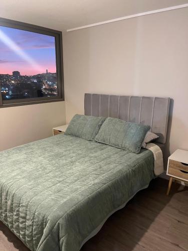 a bedroom with a bed with a large window at Santa Rosa del Mar, Departamento in Coquimbo