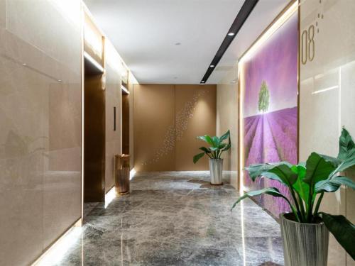 a hallway with potted plants in a lobby at Lavande Hotel Zhongshan Lihe Square in Zhongshan