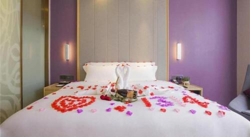 a bed with a heart made out of flowers on it at Lavande Hotel Huizhou Shiwan in Huizhou