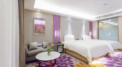 a bedroom with a large bed and a couch at Lavande Hotel Huizhou Shiwan in Huizhou